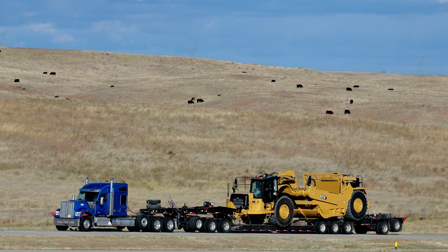 Heavy-haul lowboy trailer carrying construction equipment
